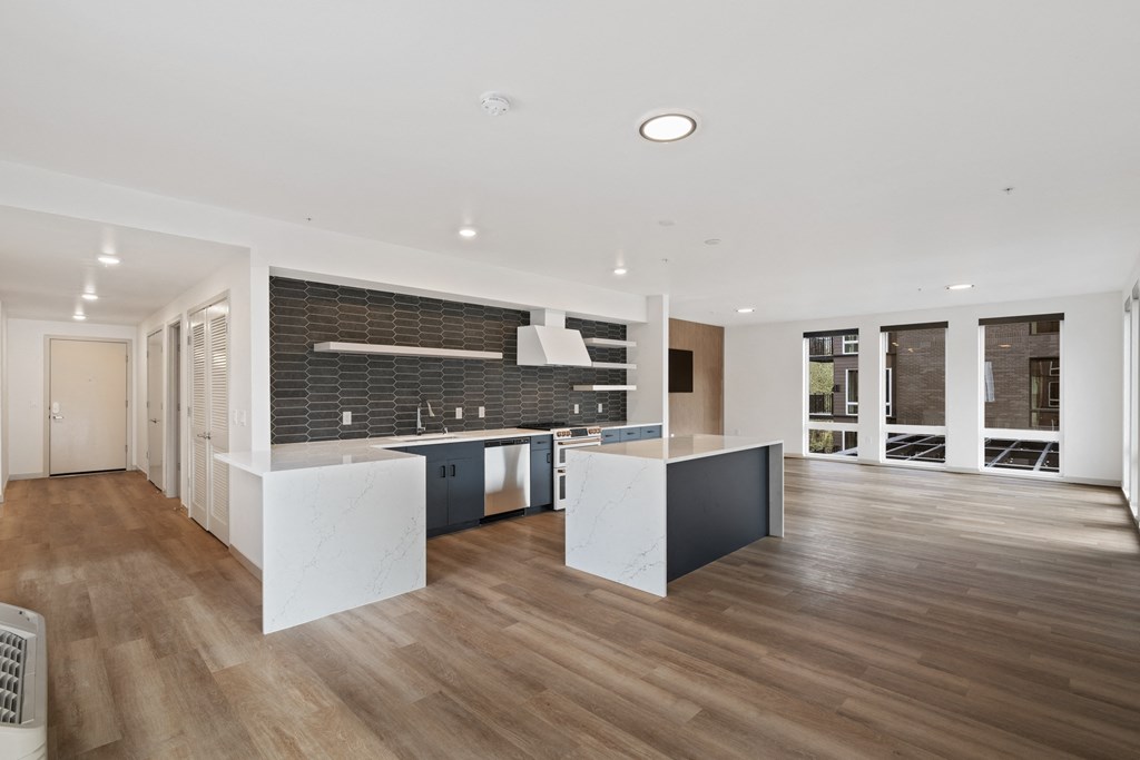 a large kitchen with white countertops and a black