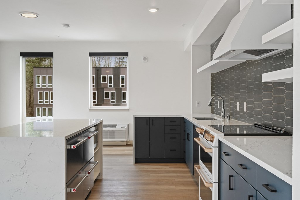 a large kitchen with black cabinets and white counter tops and a black and white