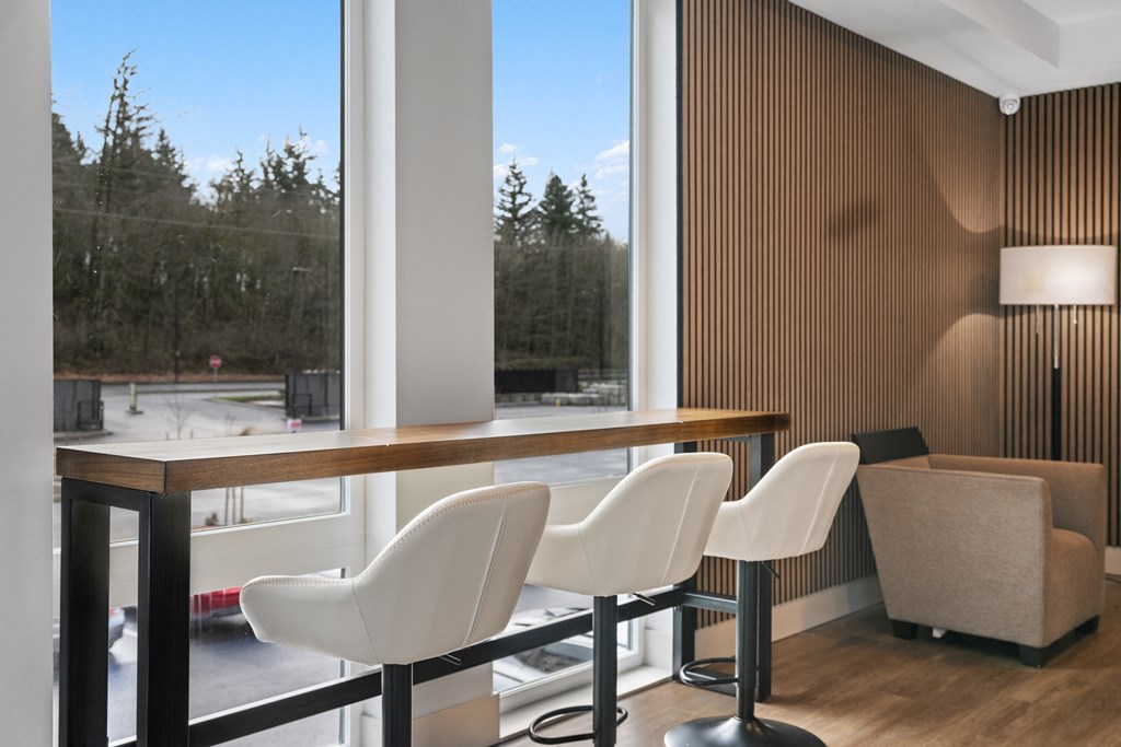 a room with a table and chairs in front of a large window
