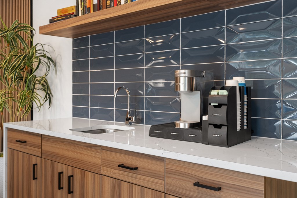 a kitchen counter with a coffee maker and a sink