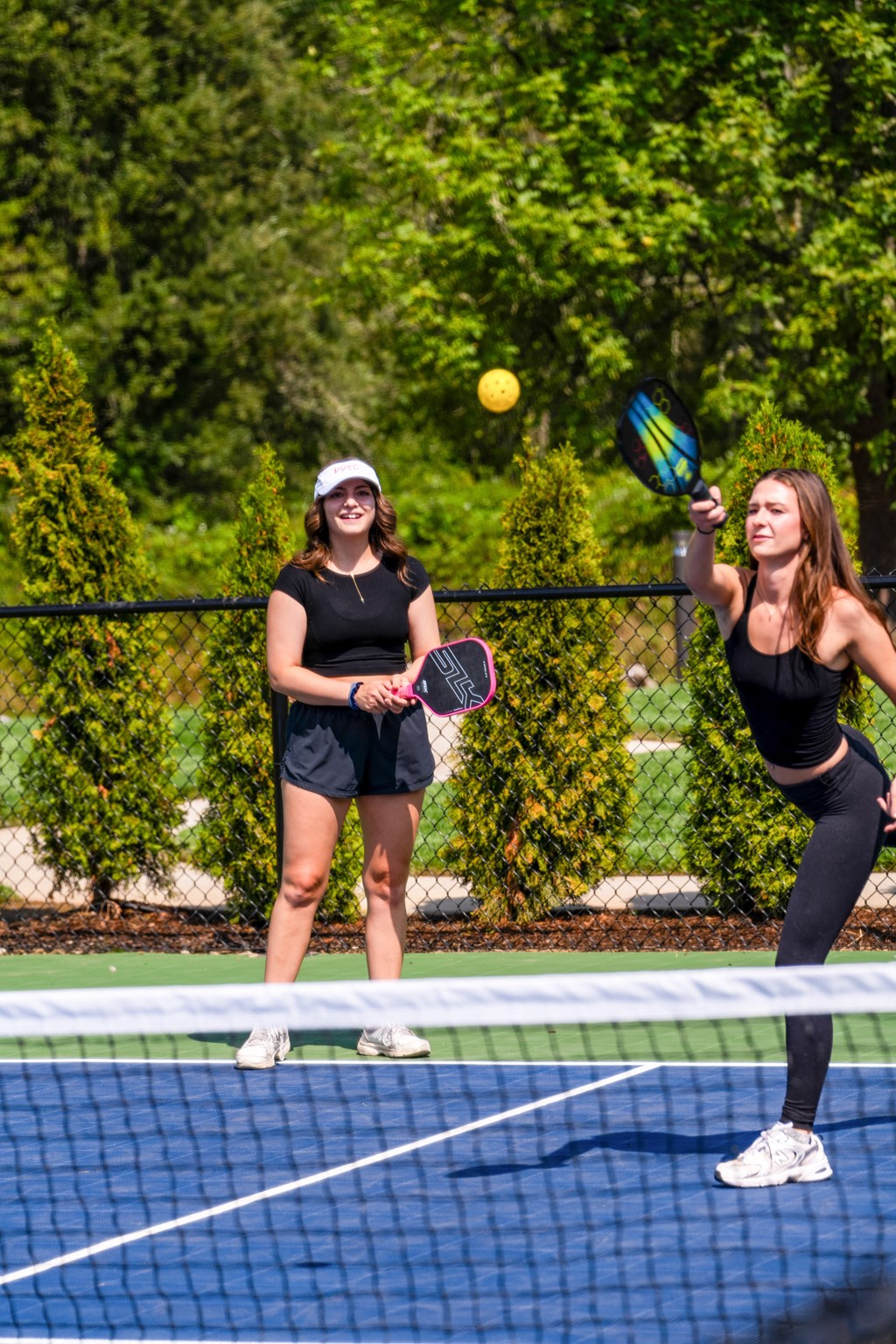 two women playing tennis on a tennis court