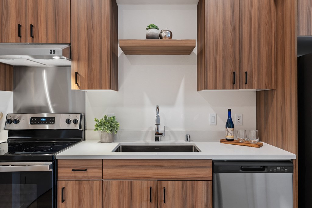 a kitchen with wooden cabinets and white counters and a sink