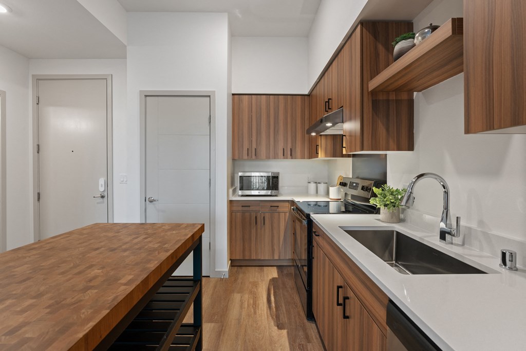 a kitchen with wooden cabinets and white countertops and a sink