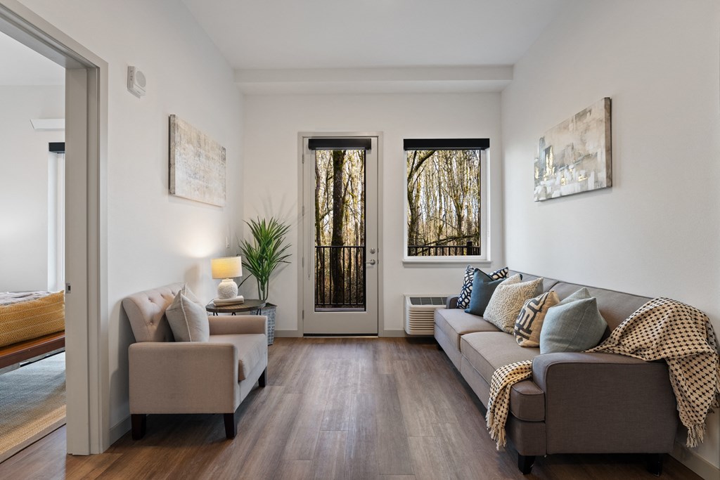 a living room with a couch and two chairs and a door