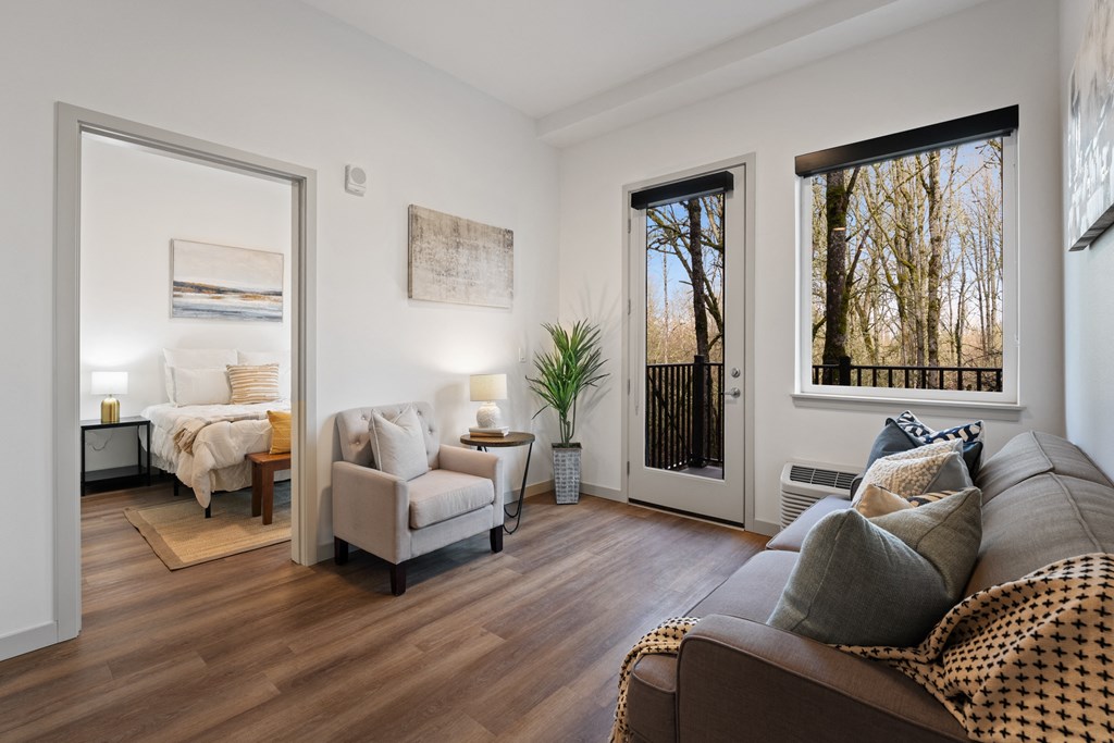 a living room with a couch and chairs and a door to a bedroom
