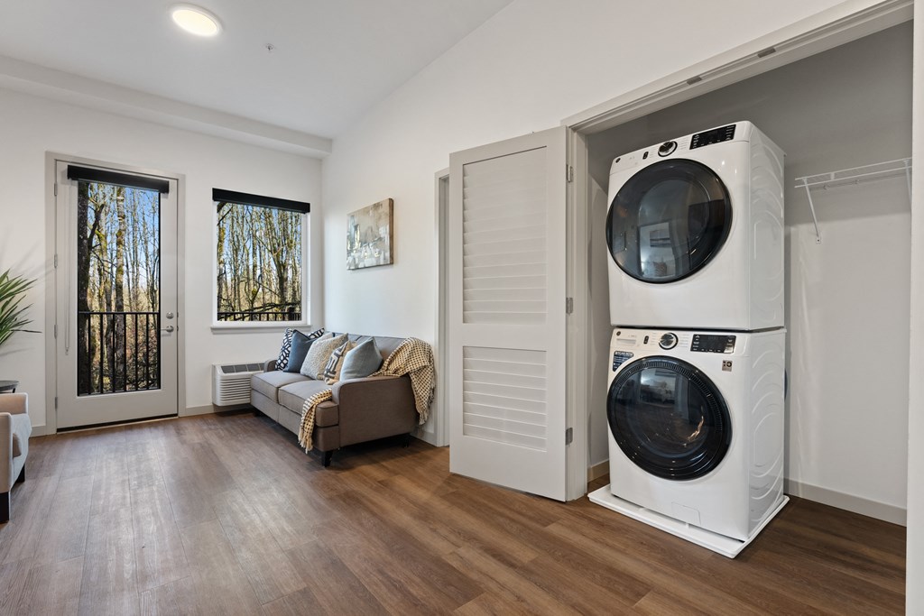 a washer and dryer in a room with a door to a living room