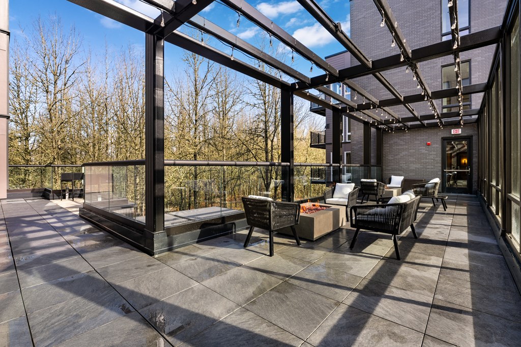 a covered patio with chairs and tables and a fireplace