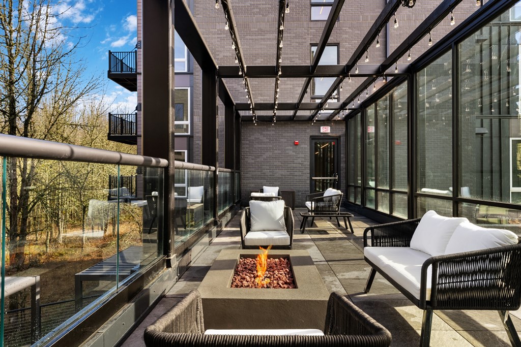 a patio with chairs and a fire pit