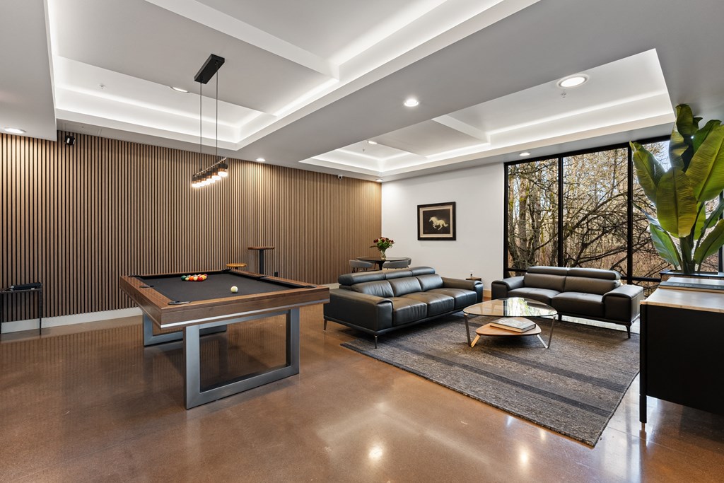 a game room with a pool table and couches