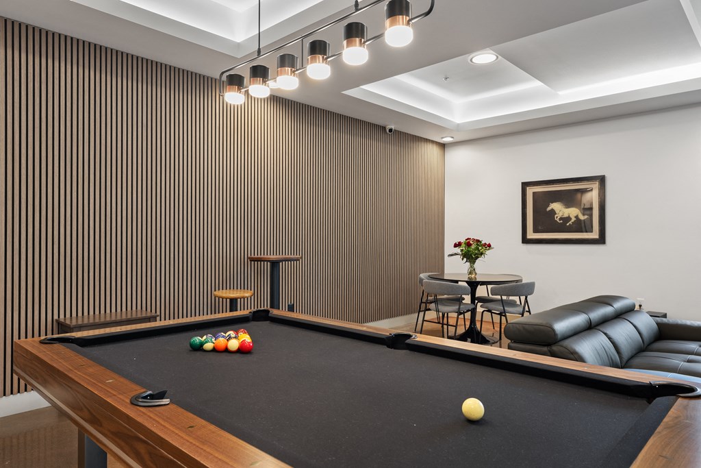 a game room with a pool table and chairs