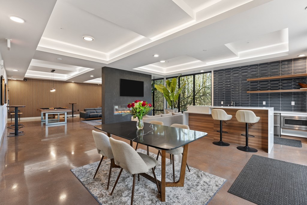 a dining room with a black table and chairs and a living room