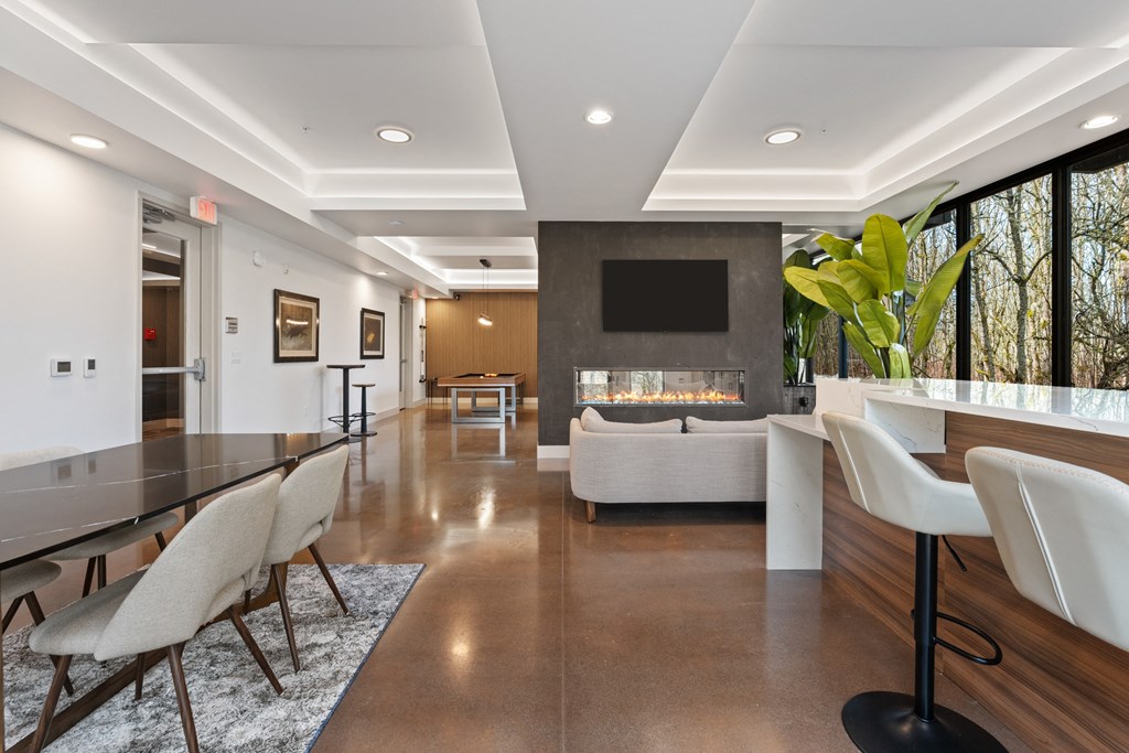 a large living room with a fireplace and a table and chairs