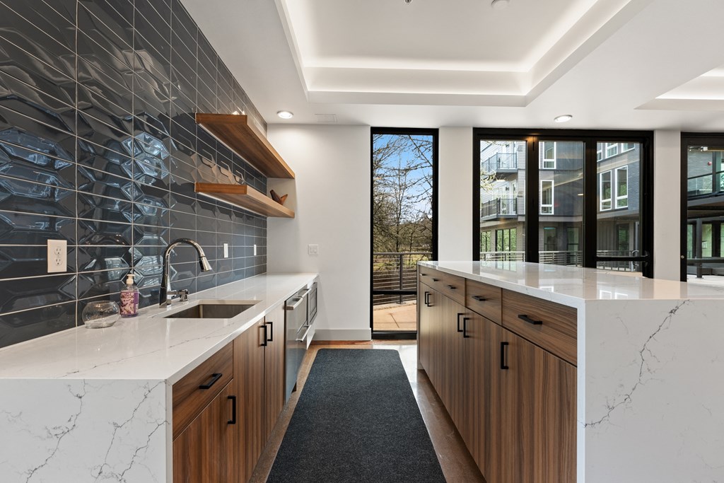 a large kitchen with marble counter tops and wooden cabinets