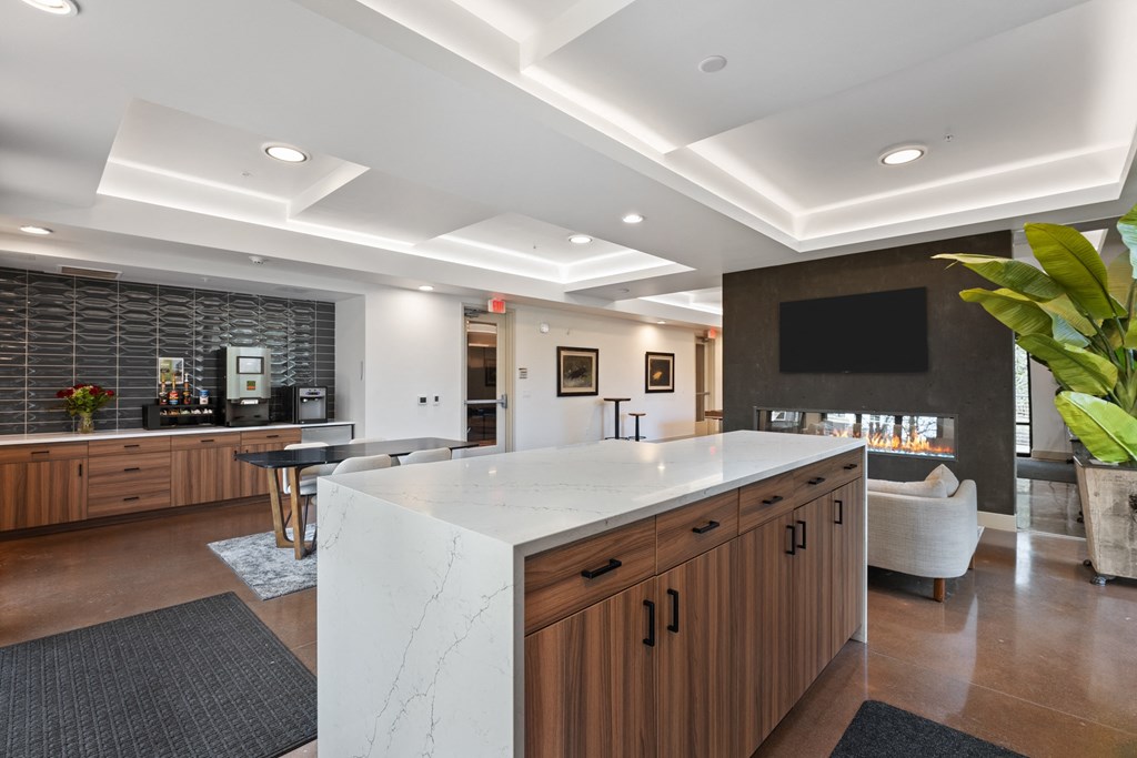 a large kitchen with a marble counter top and a bar and a living room