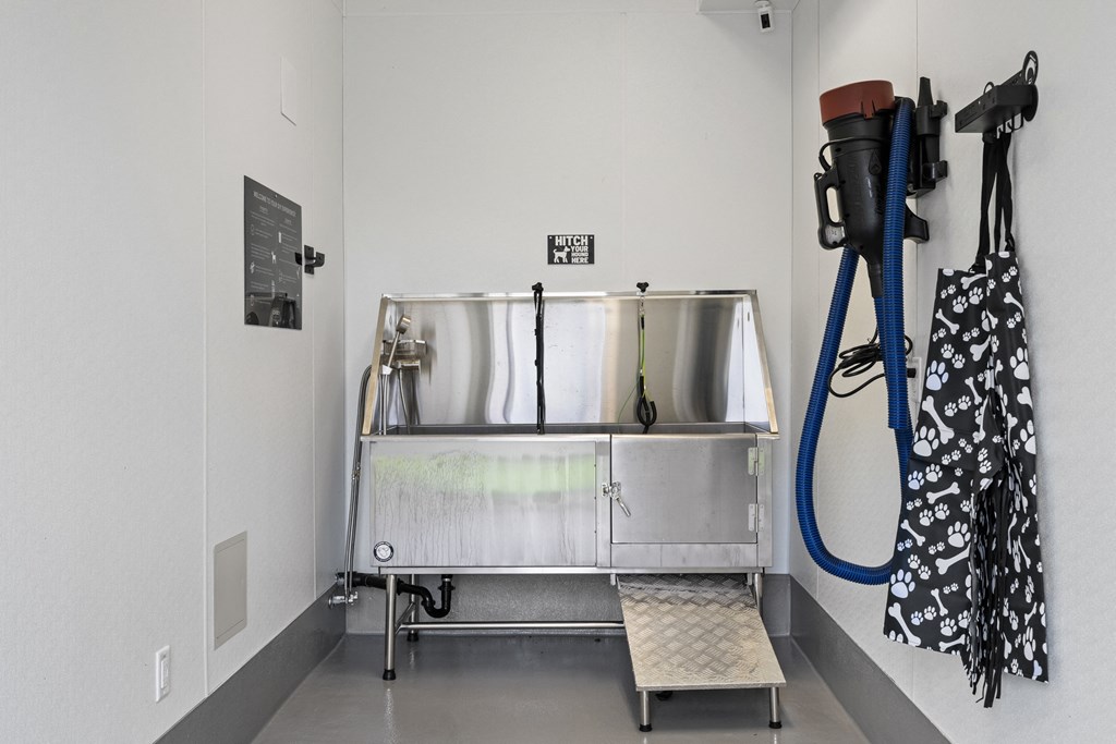 a sink in the corner of a room with a hose and a vacuum
