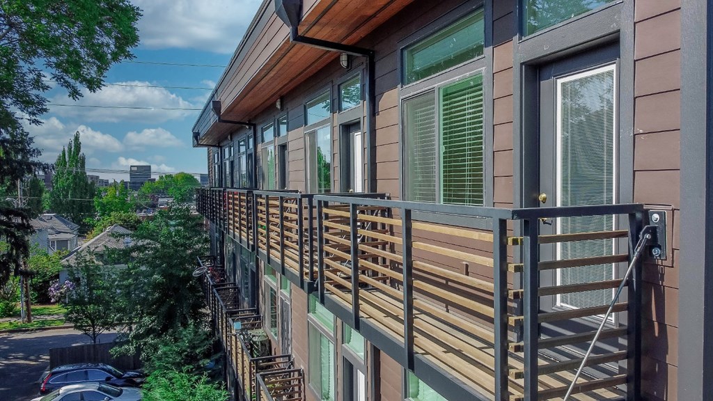 a balcony with a wooden railing and a city in the background
