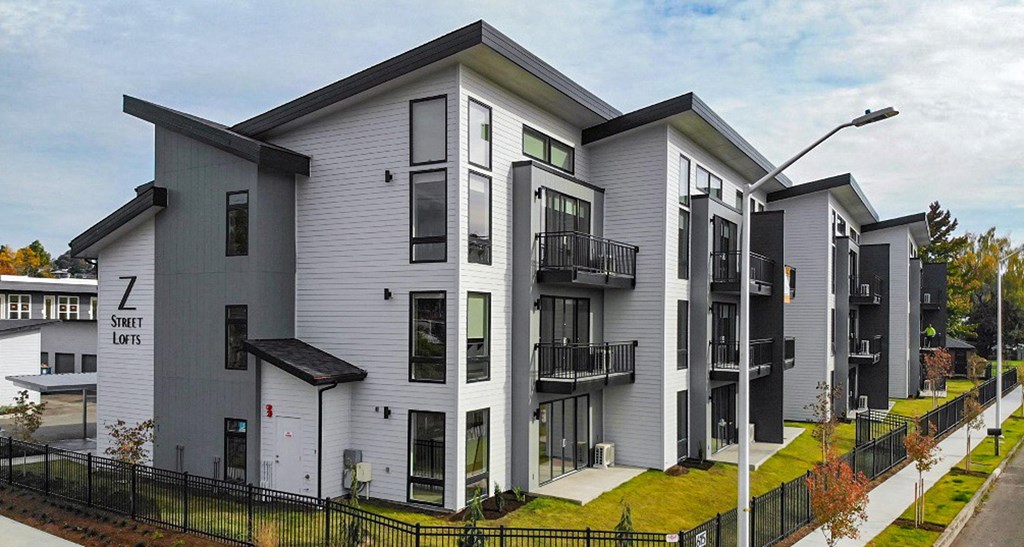a row of town houses with balconies and a sidewalk