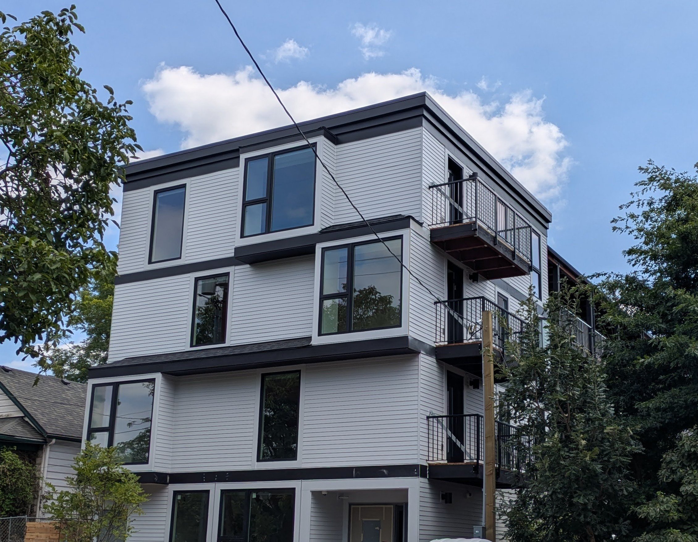 A modern multi-story building with balconies and large windows.