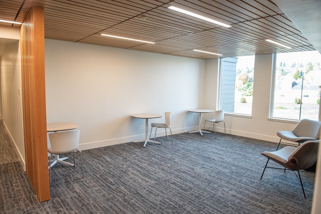 a room with tables and chairs and a large window