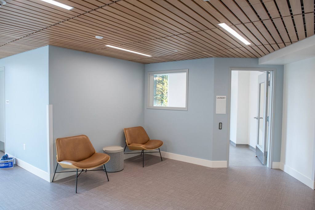a waiting room with two chairs and a window