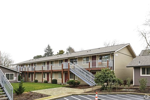 A building with a parking lot in front.