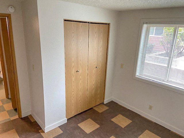 an empty room with a closet and a window