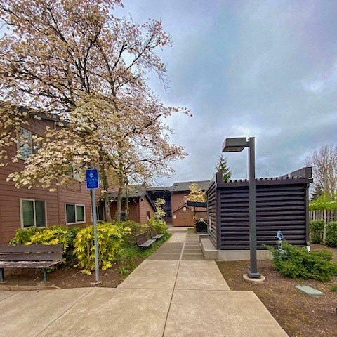 a sidewalk in front of a building with a bench