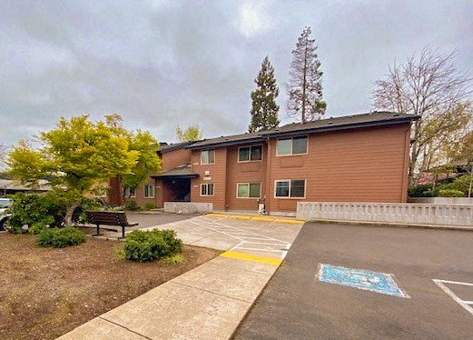 a brick building with a bench in a parking lot