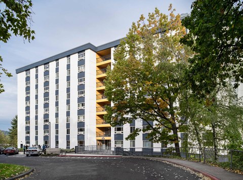 A modern multi-story building with a mix of blue and white panels.