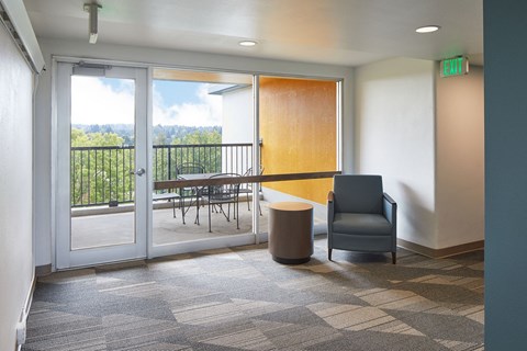 a room with a chair and a table on a balcony