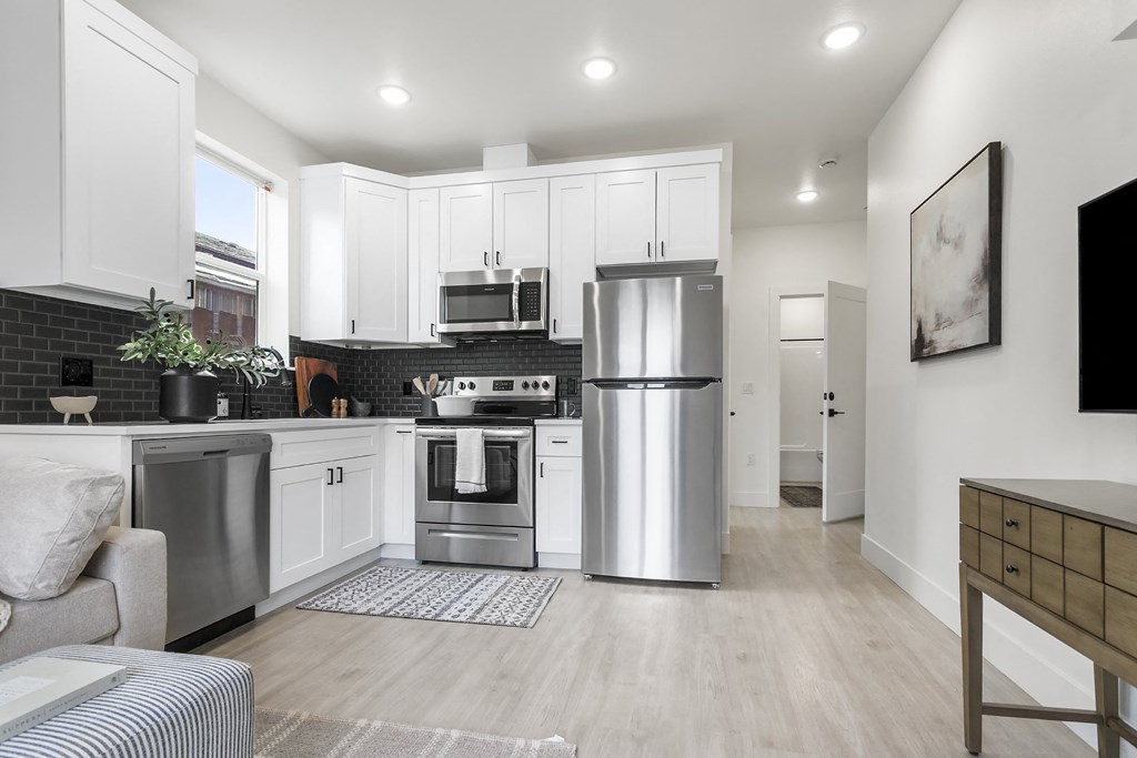 a kitchen with stainless steel appliances and white cabinets