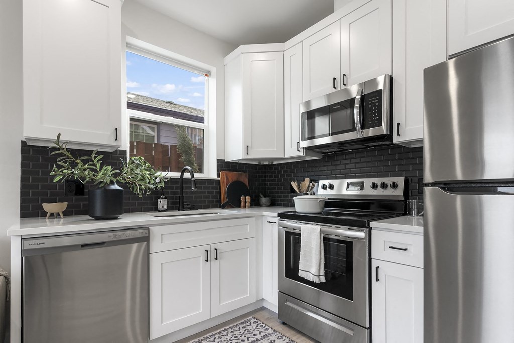 a kitchen with stainless steel appliances and white cabinets