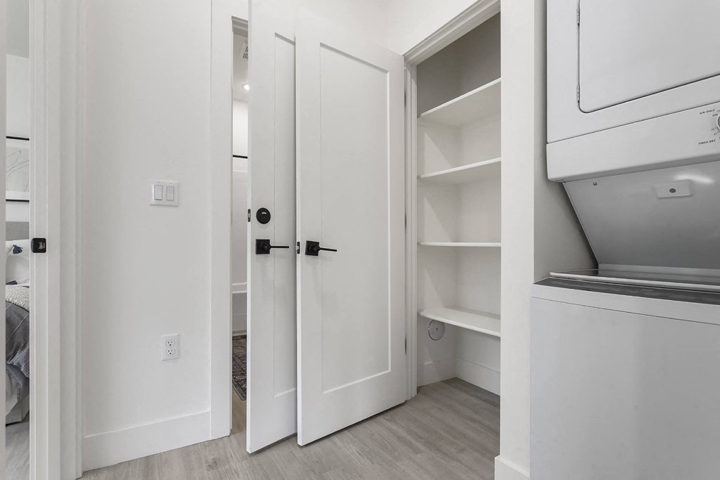 a bedroom with a closet and a washer and dryer