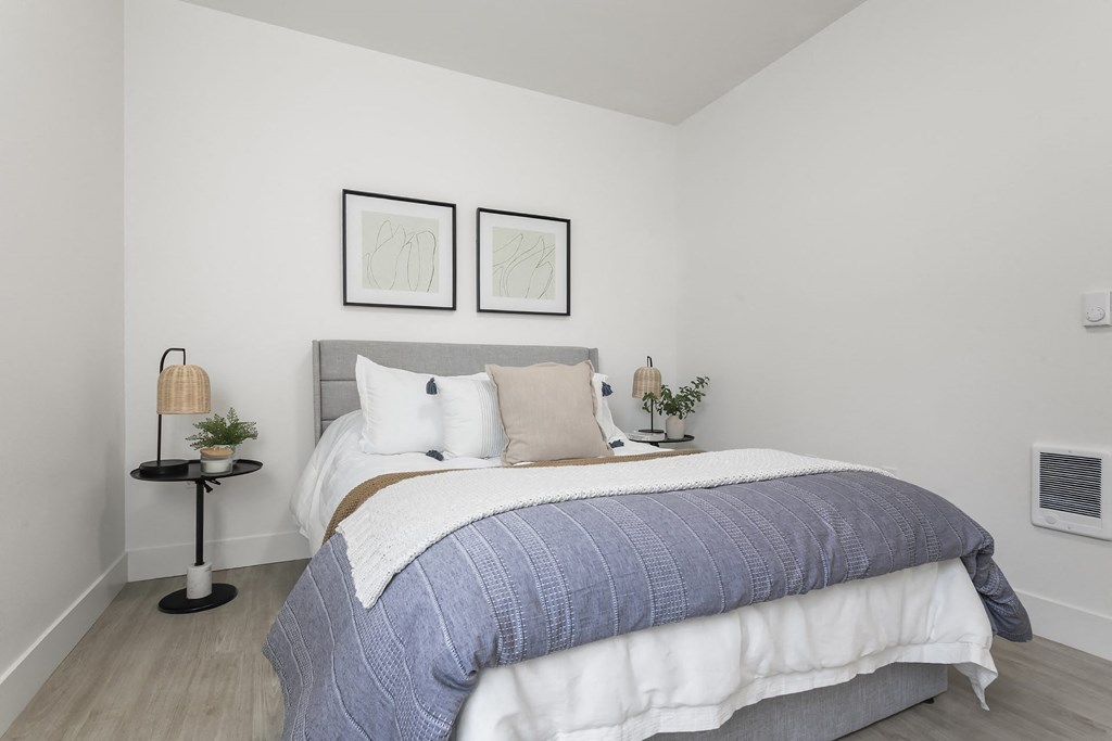 a bedroom with a bed and two pictures on the wall