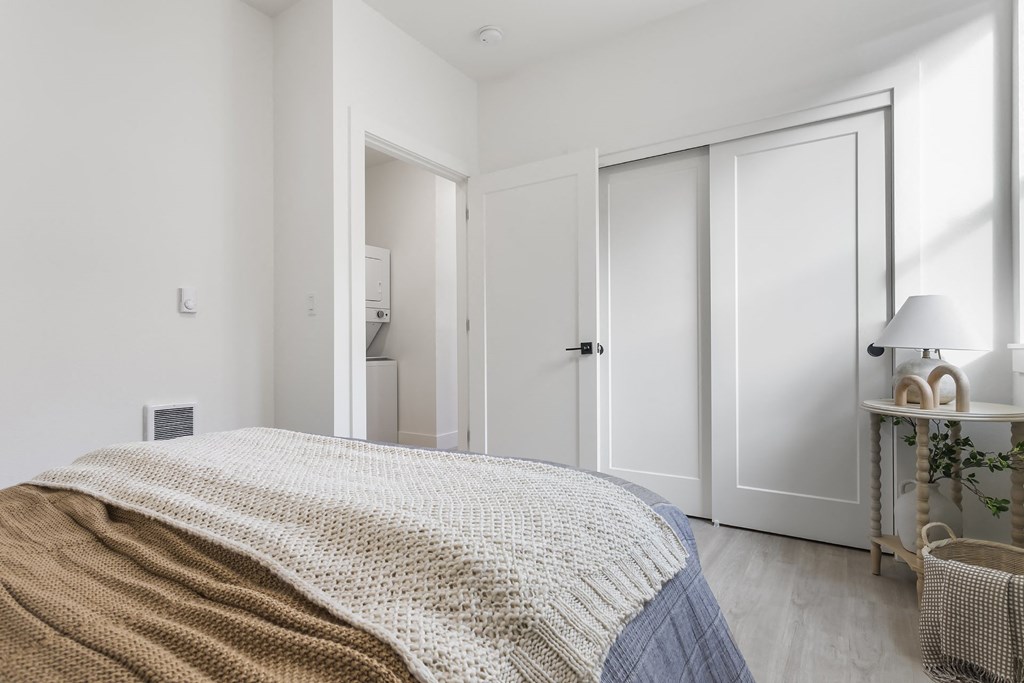 a bedroom with a bed and white closet doors