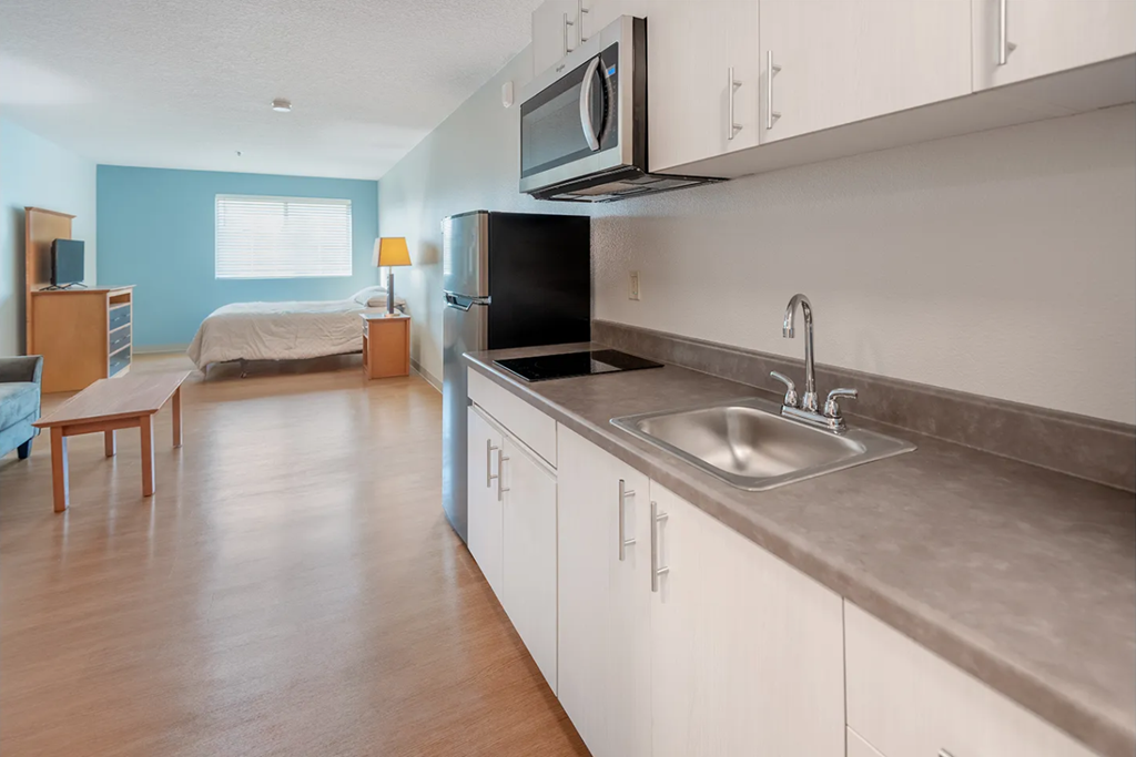 A kitchen with a sink and a refrigerator.