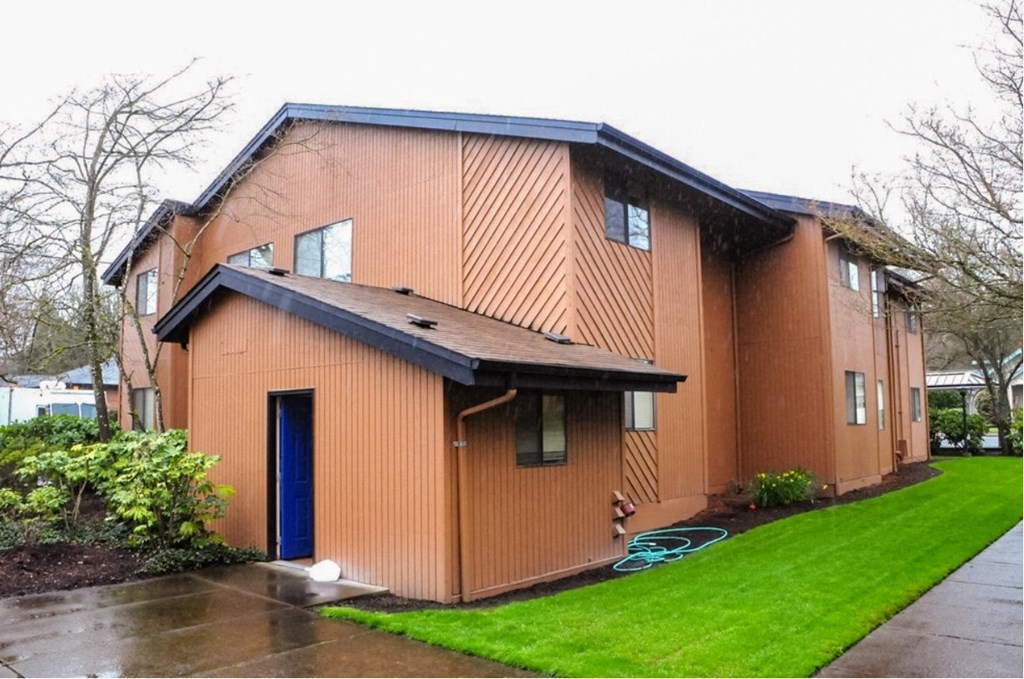 a brown house with a blue door on a rainy day
