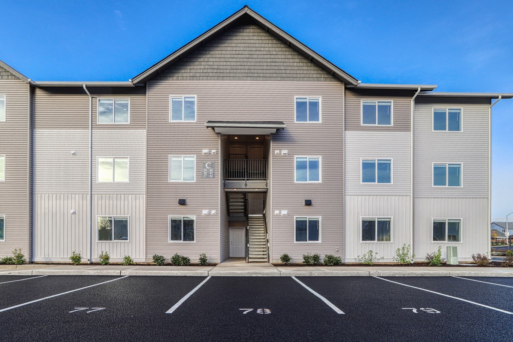 A large building with a parking lot in front of it.