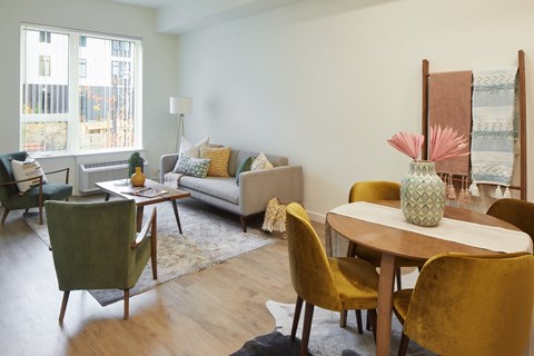 A living room with a couch, chairs, and a table.