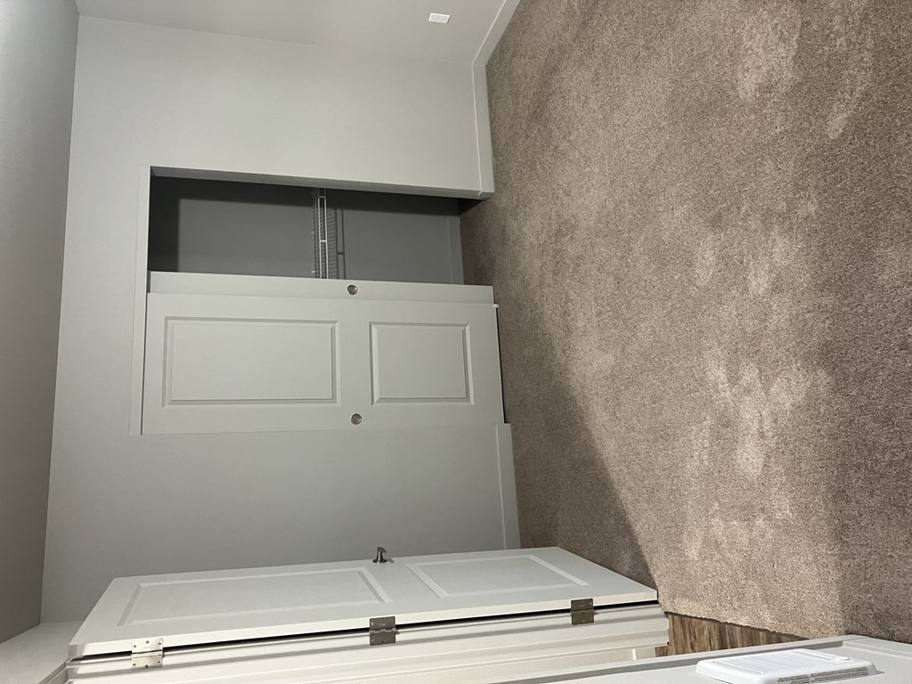 a white door in a wall next to a white desk