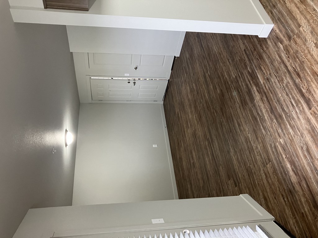 an overhead view of an empty room with wood flooring and a desk