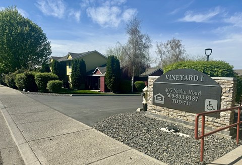 A sign for Vineyard I is in front of a house.