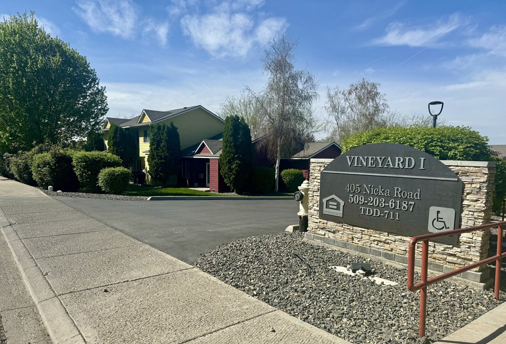 A sign for Vineyard I is in front of a house.