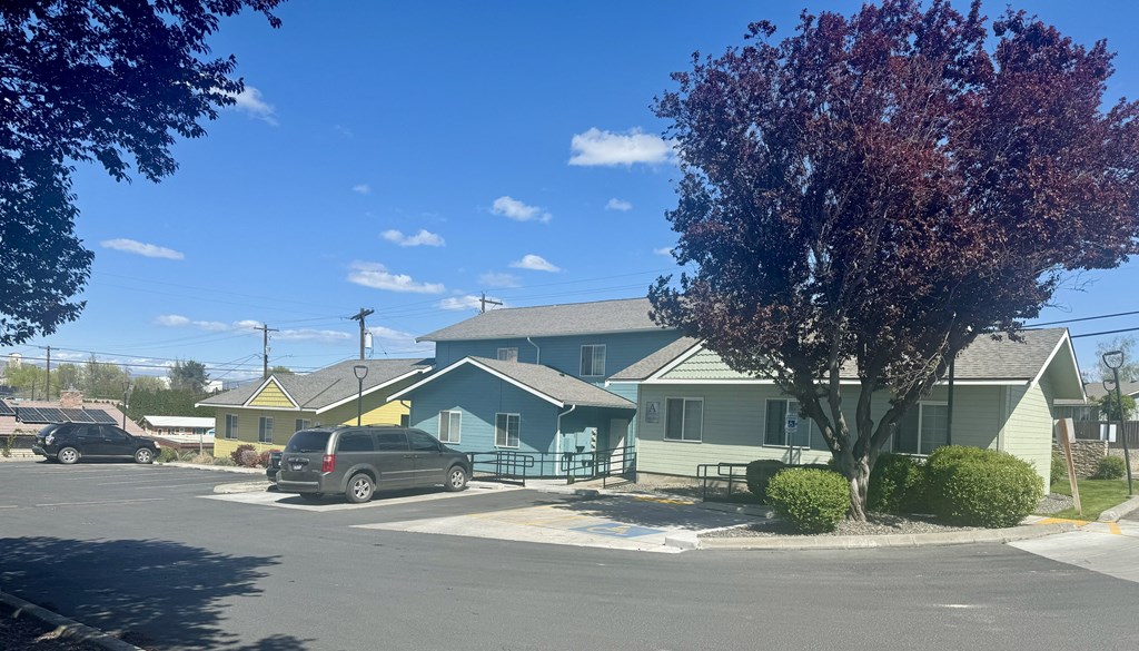 A blue building with a green tree in front of it.