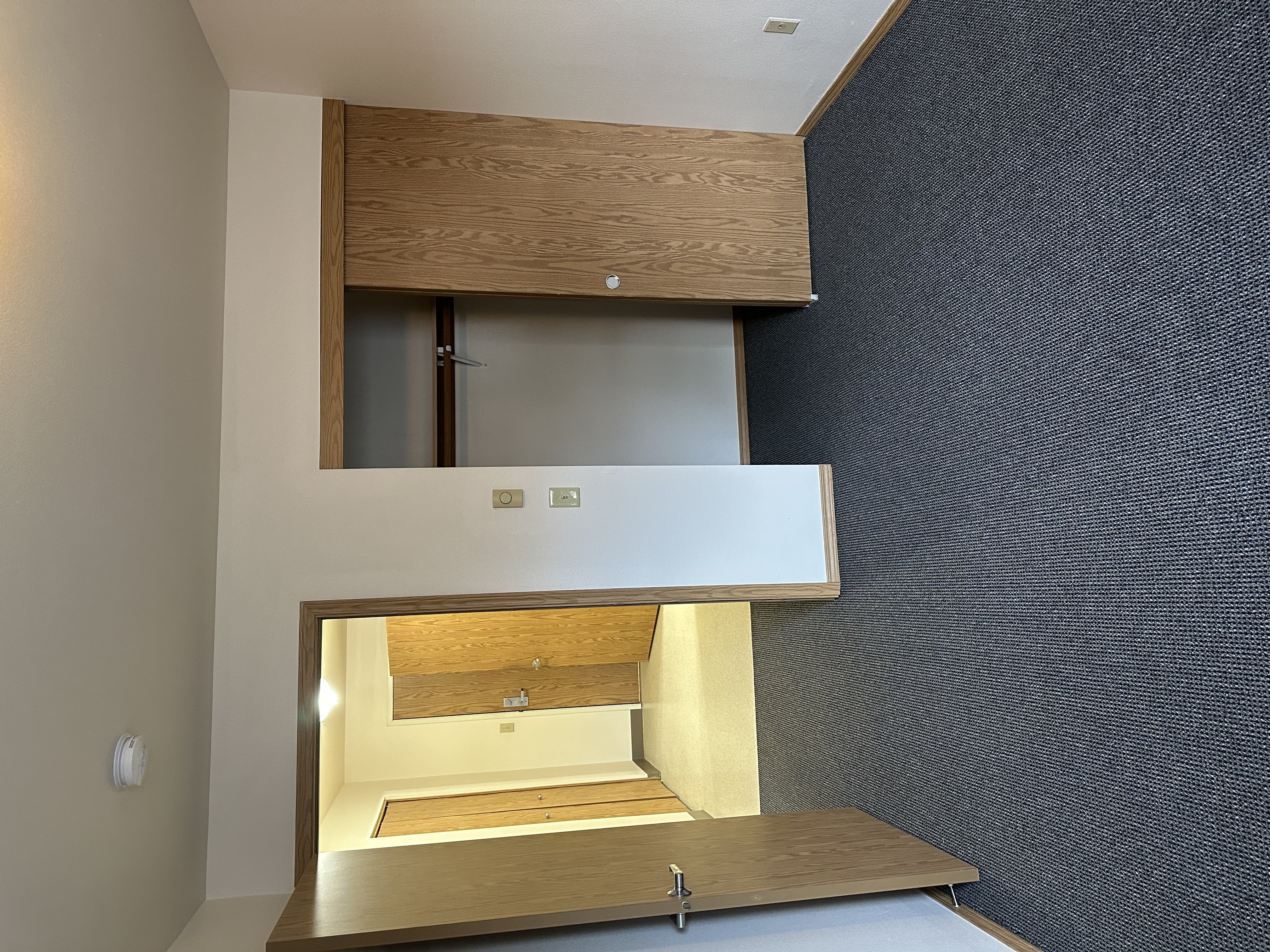 A modern, minimalist kitchen with a wooden cabinet and a countertop.