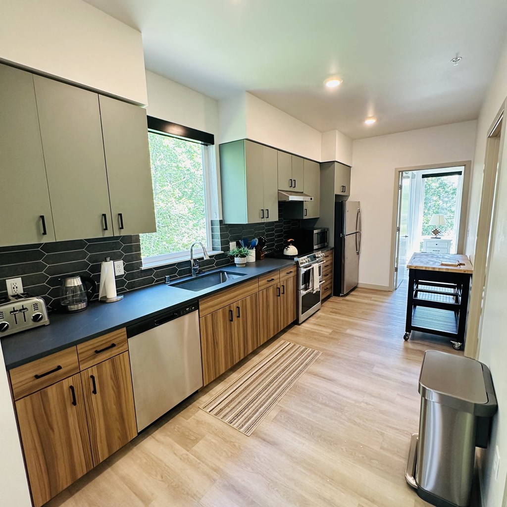 a view of a kitchen with black counter tops and wooden cabinets