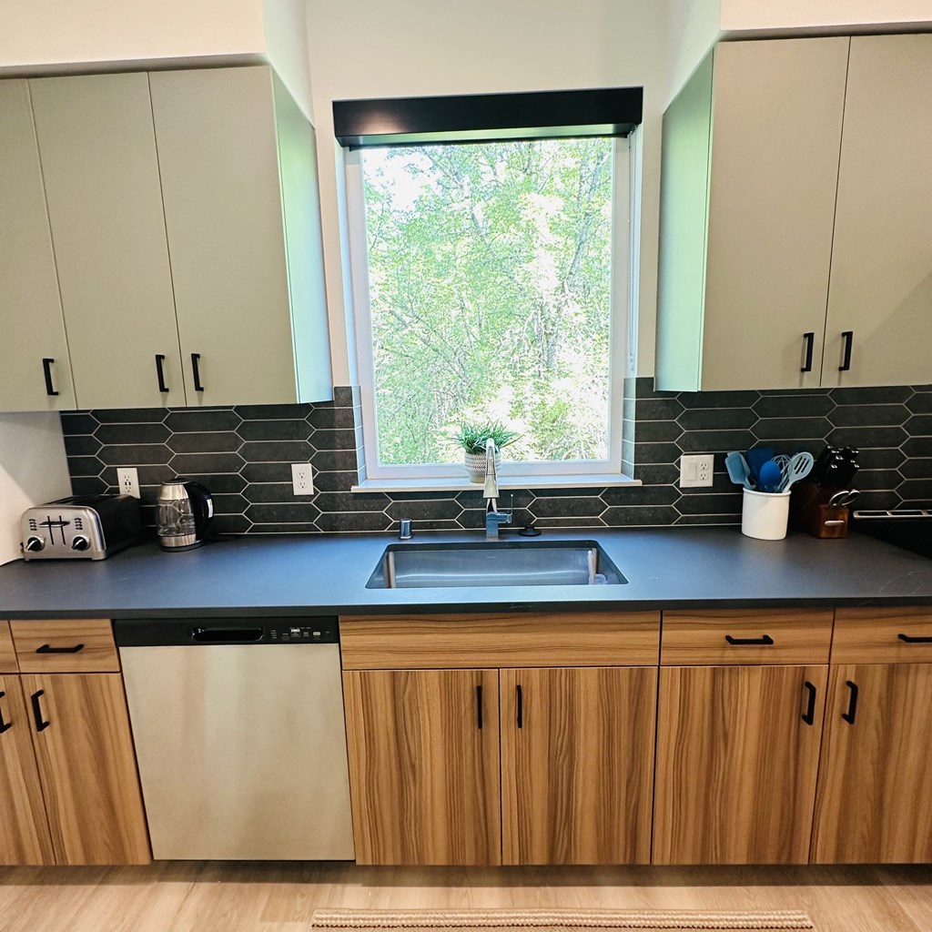 a kitchen with wooden cabinets and a sink and a window