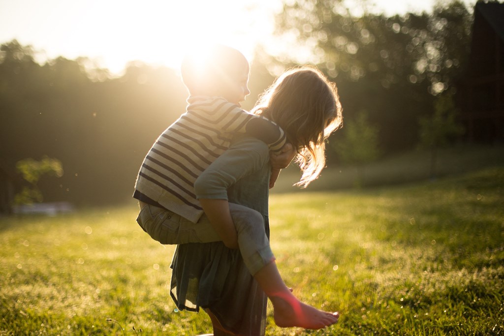 a boy and a girl hugging in the sun