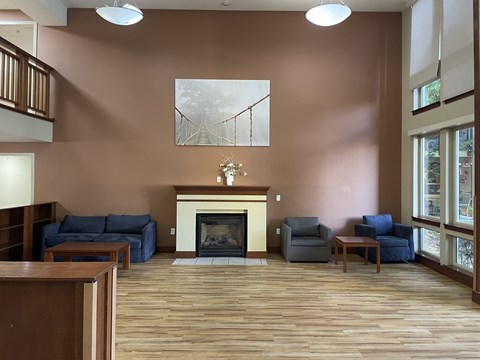 A living room with a fireplace and a painting on the wall.