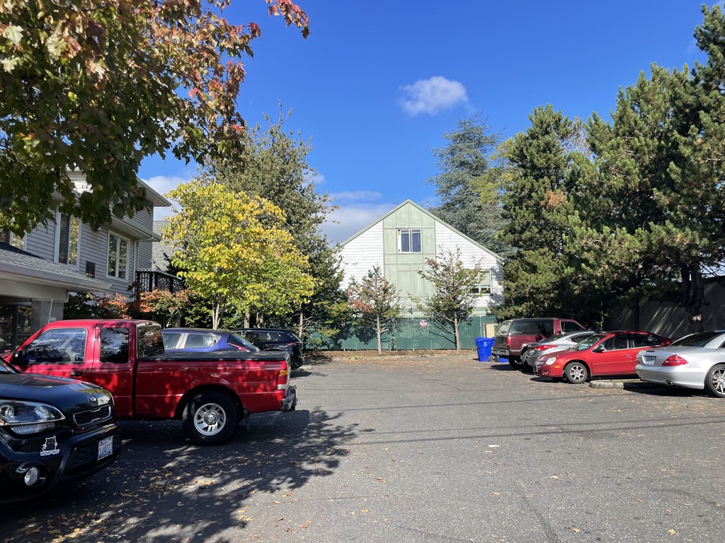 A red pickup truck is parked in a lot with other vehicles.